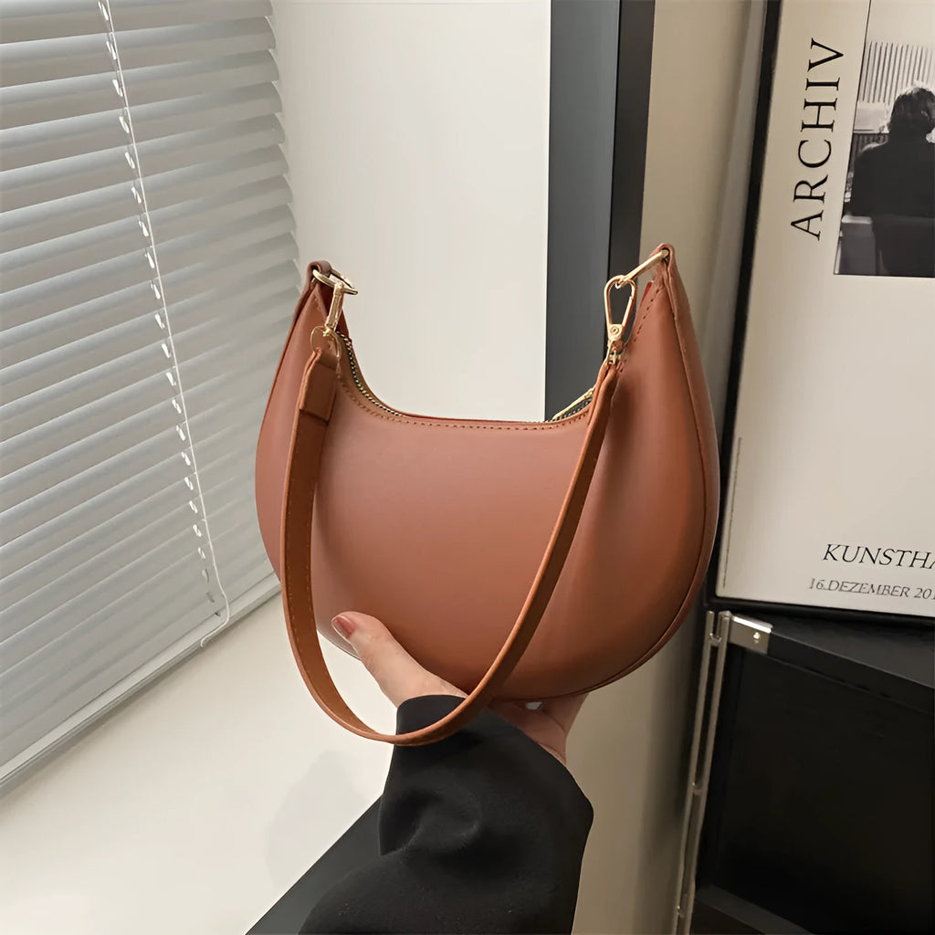 Round one-shoulder underarm bag in PU material, shown in green colour with visible sewing lines and a single strap.