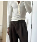 Men's cream coloured ribbed long sleeve Henley top with button placket on a mannequin.