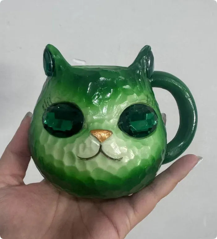 Small solid-colour resin cat cup craft figurine on a table, shown in purple, green, blue, and pink colour variants.