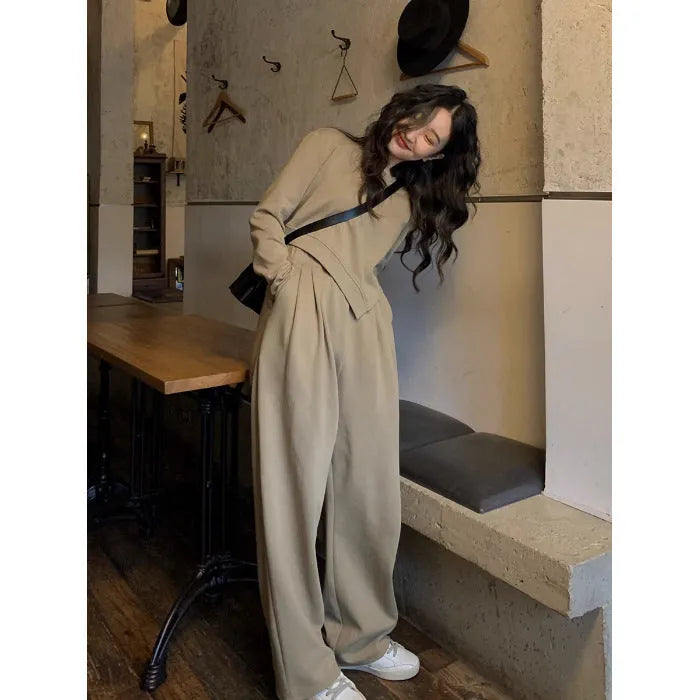 Women's loose brown polyester sports suit with top and trousers on a hanger.