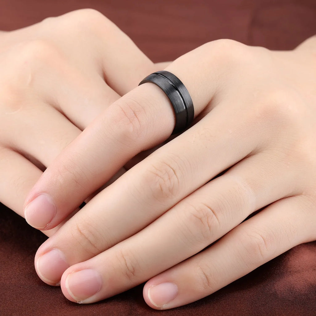 Black titanium steel ring with geometric design and alloy inlaid artificial stone on a dark background.