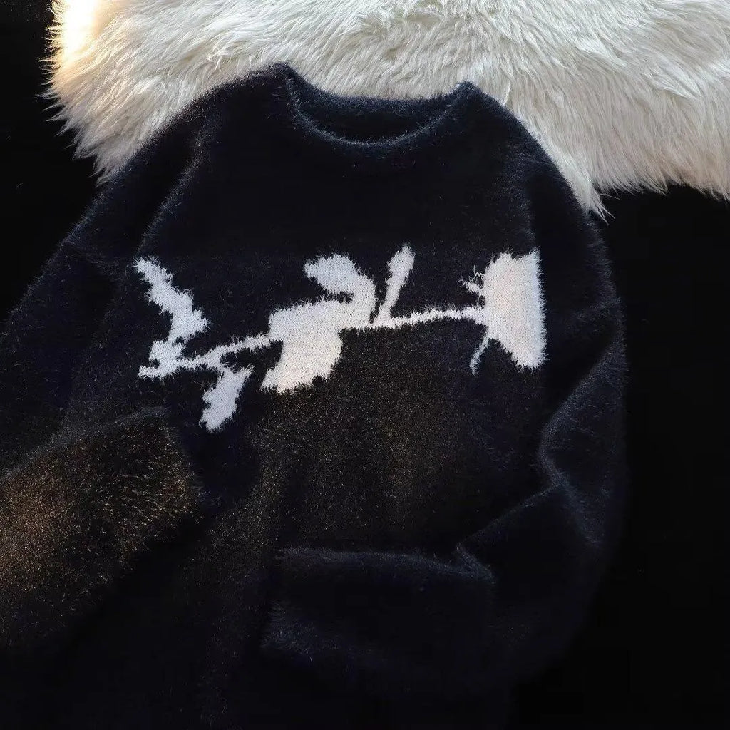 Man wearing a dark grey pullover sweater with a large rose-coloured flocking horse print on the chest.