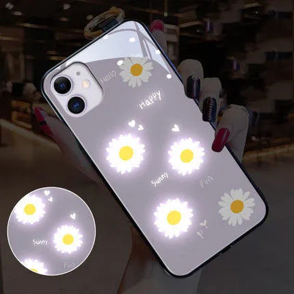 White iPhone case with painted daisies and a voice-activated coloured light strip on the back.