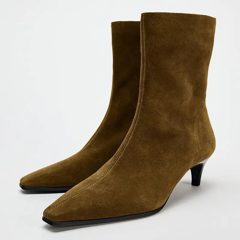 Brown square toe kitten heel mid-calf boots with side zipper on a wooden floor.