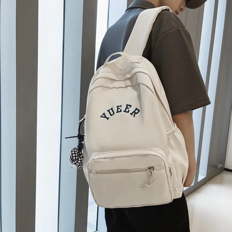 Simple nylon backpack for women, 32cm, with computer pocket, in five colours including black, blue, red, white, and light green.