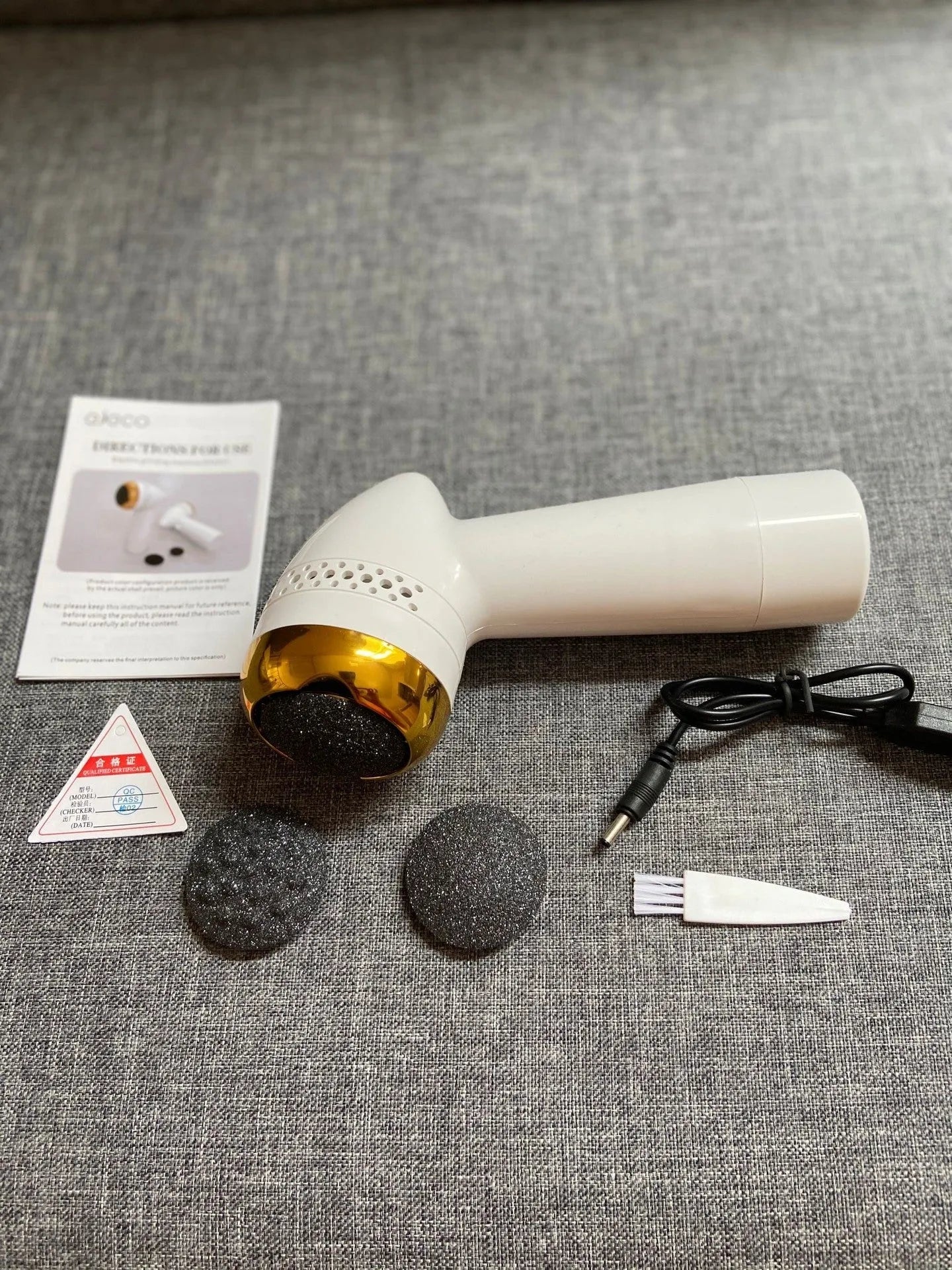 Gold-coloured electric vacuum foot grinder with a refined quartz grinding head on a white background.