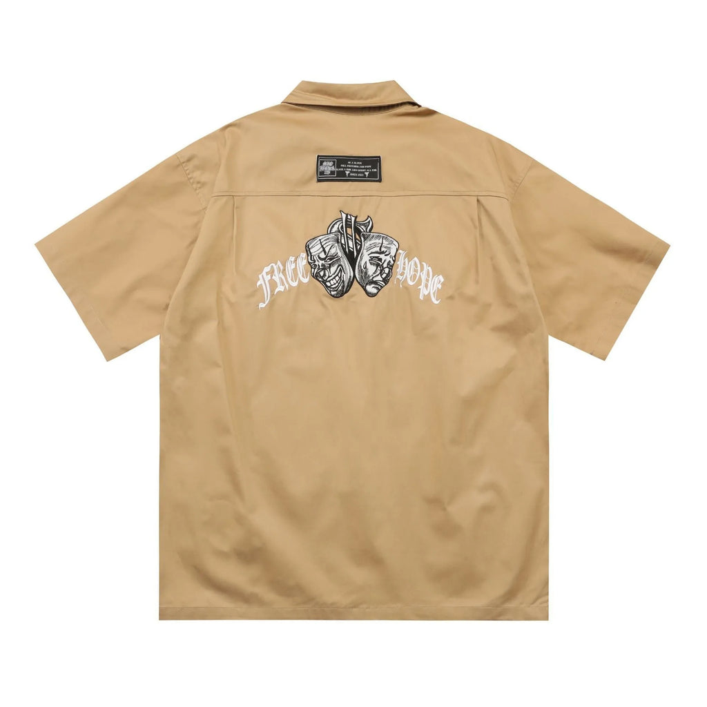 Man's black loose-fit pocket shirt with embroidery and half sleeves on a hanger.