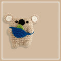 Handmade knitted koala bear backpack design cover on an AirPods case.
