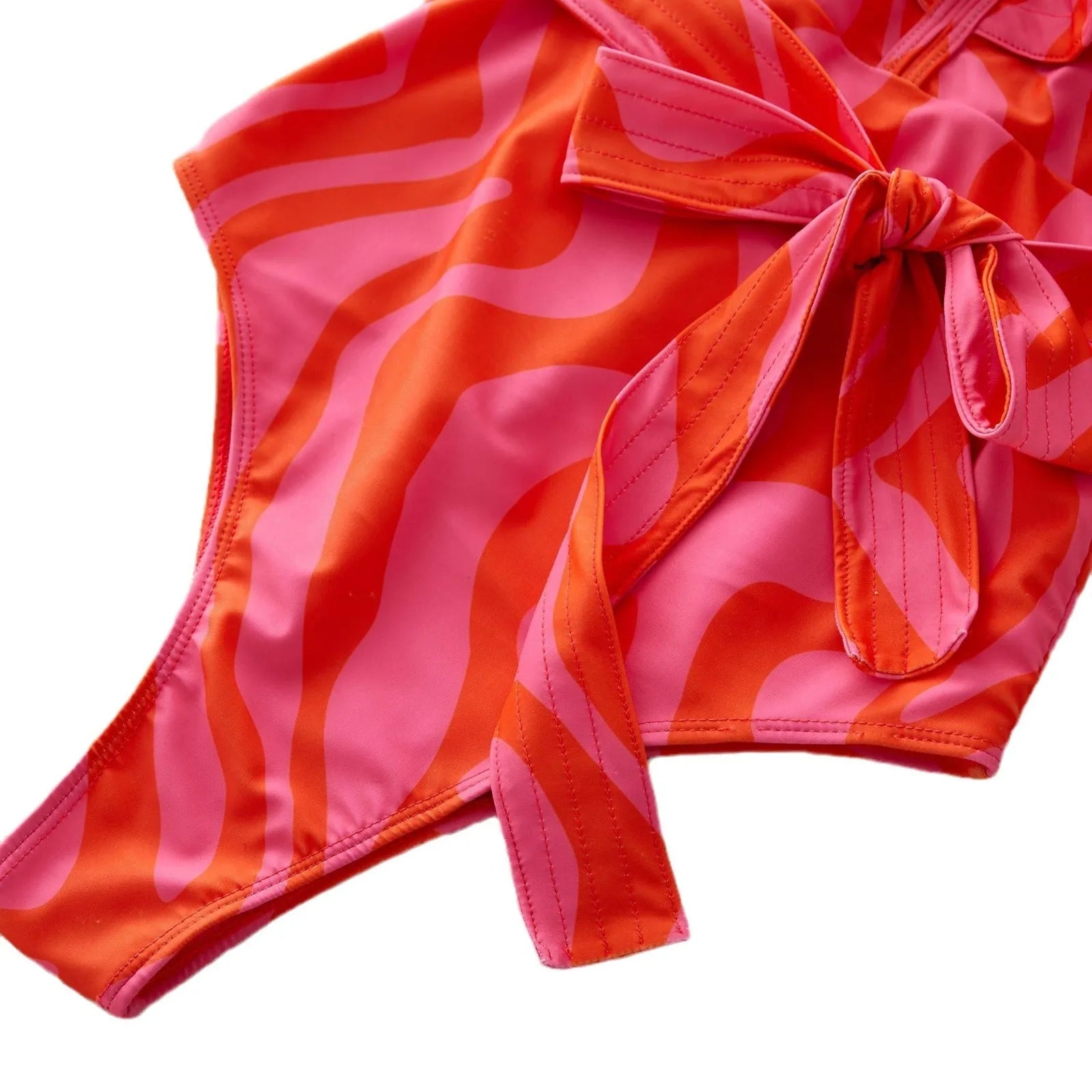 Women's printed one-piece swimsuit with double shoulder straps and ruffled mesh detail on a deep V-neck.