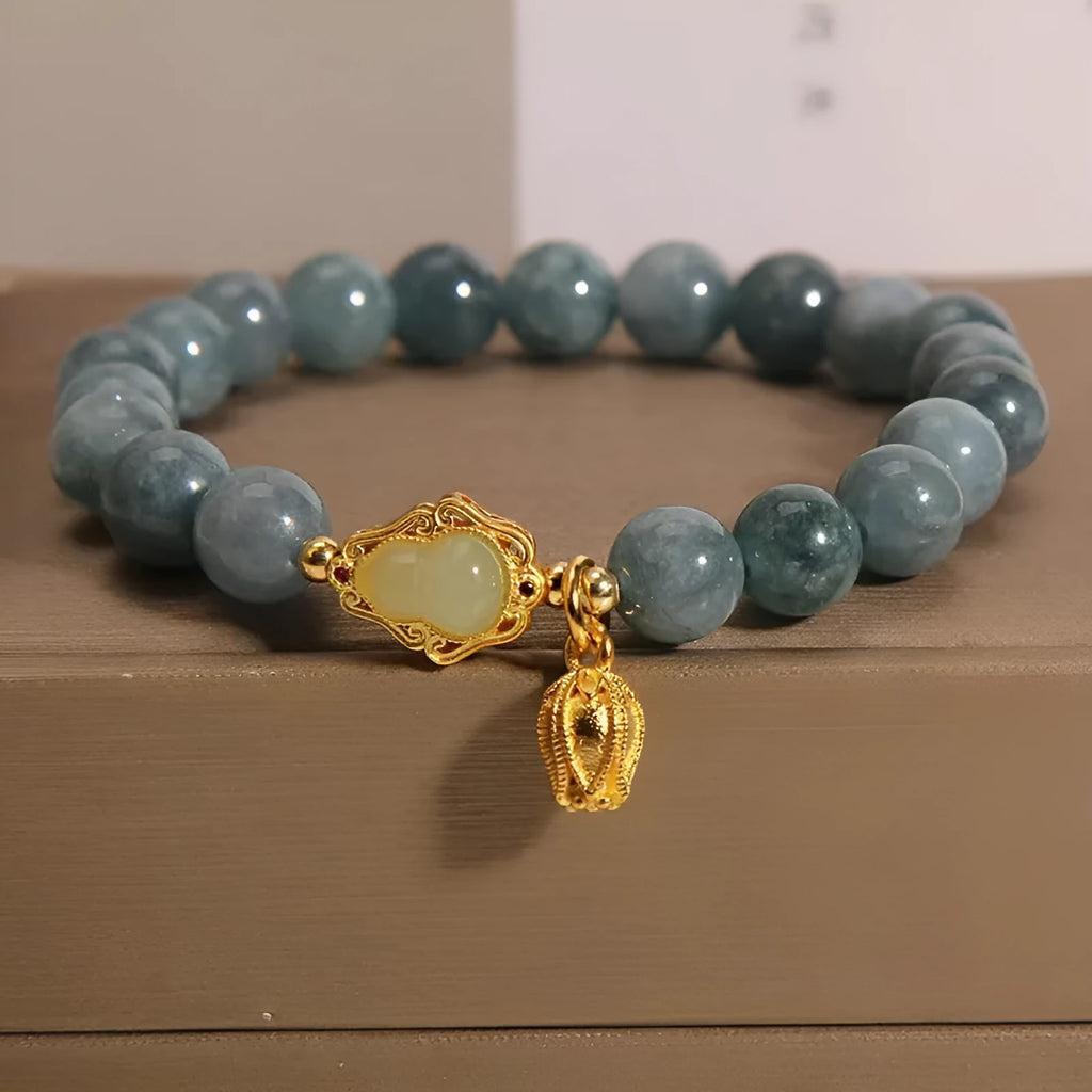 Sky blue natural stone gourd lotus pendant on a women's electroplated bracelet.