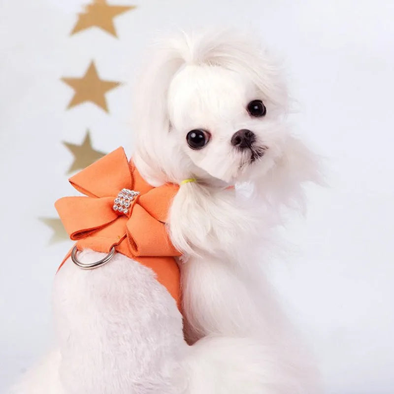 A pink microfiber dog harness with a bowknot on the chest strap, shown on a small dog.