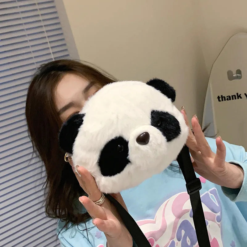 Soft plush panda head design crossbody bag in cylindrical shape on a white background.