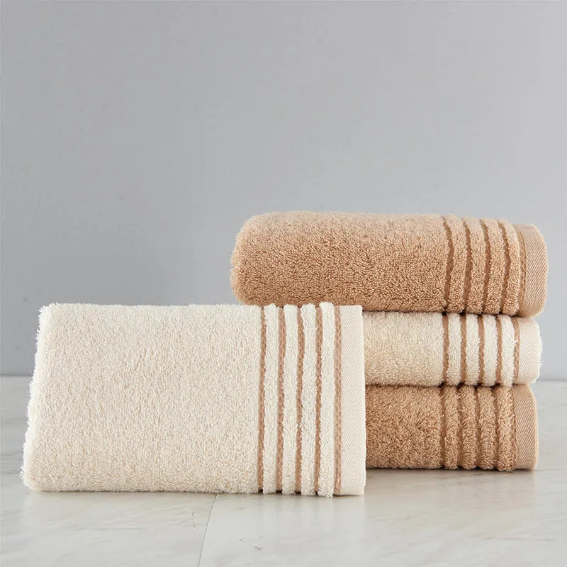 Set of three cotton towels in beige and brown including large bath towel, hand towel, and small washcloth