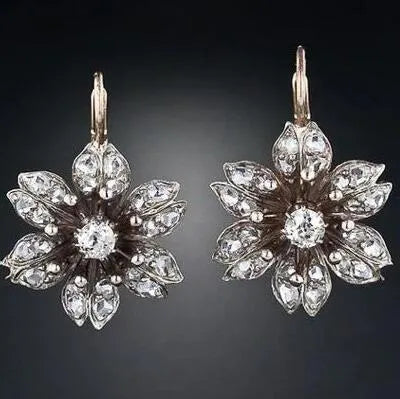 A pair of silver retro-style drop earrings for women on a white background.