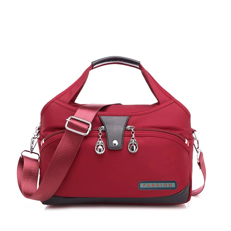Women's crossbody bag in Oxford cloth with zippered closure and adjustable shoulder strap, 29cm long, available in multiple colours