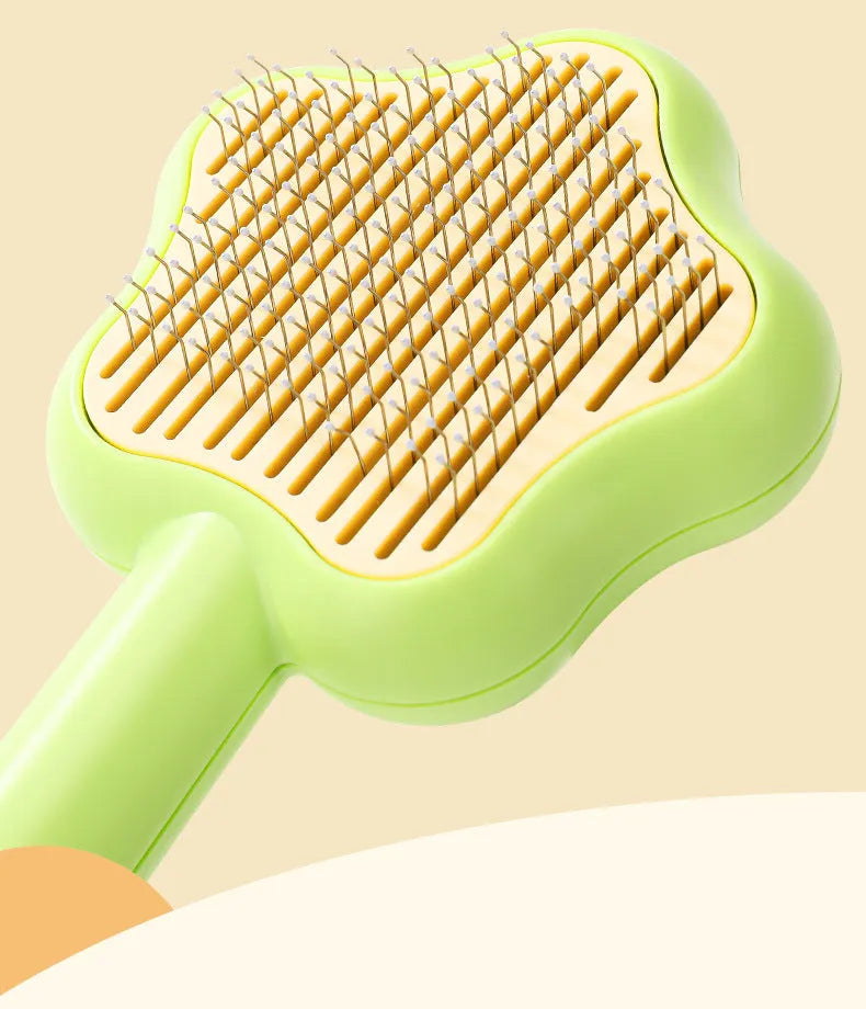 Green self-cleaning stainless steel cat comb for pet grooming on a white background