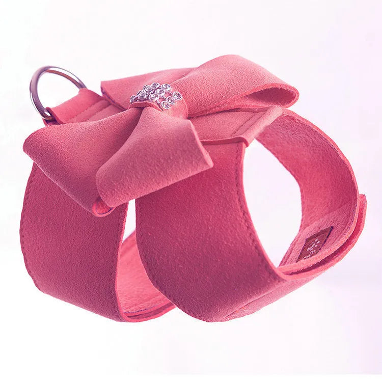 A pink microfiber dog harness with a bowknot on the chest strap, shown on a small dog.