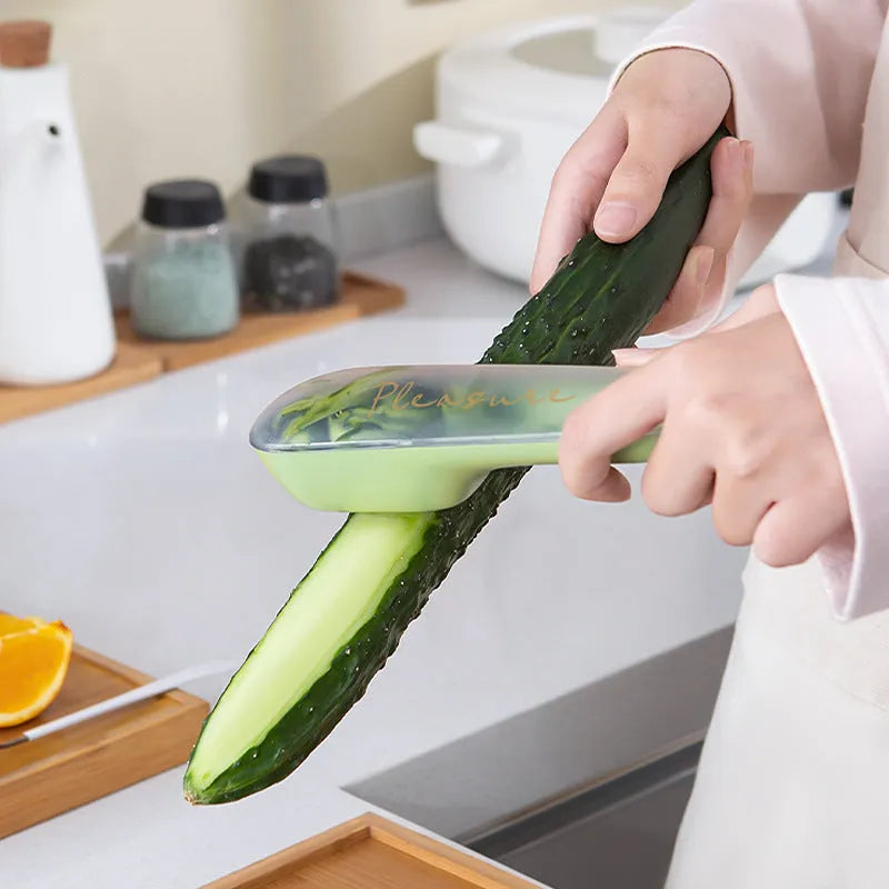 Dark green kitchen peeler with storage tube showing stainless steel blade and hanging hole