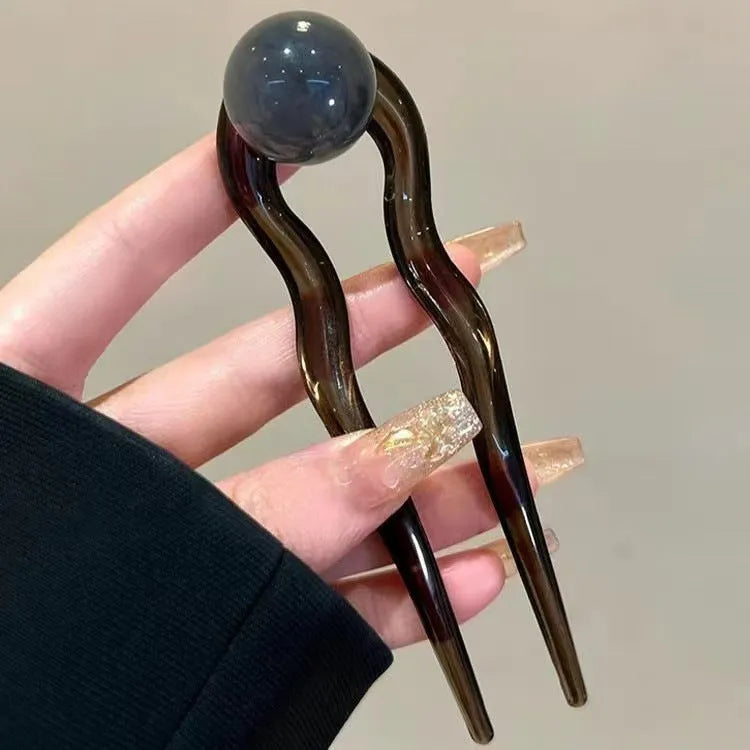 Acrylic U-shaped hair barrette with a retro ball design in a simple style.