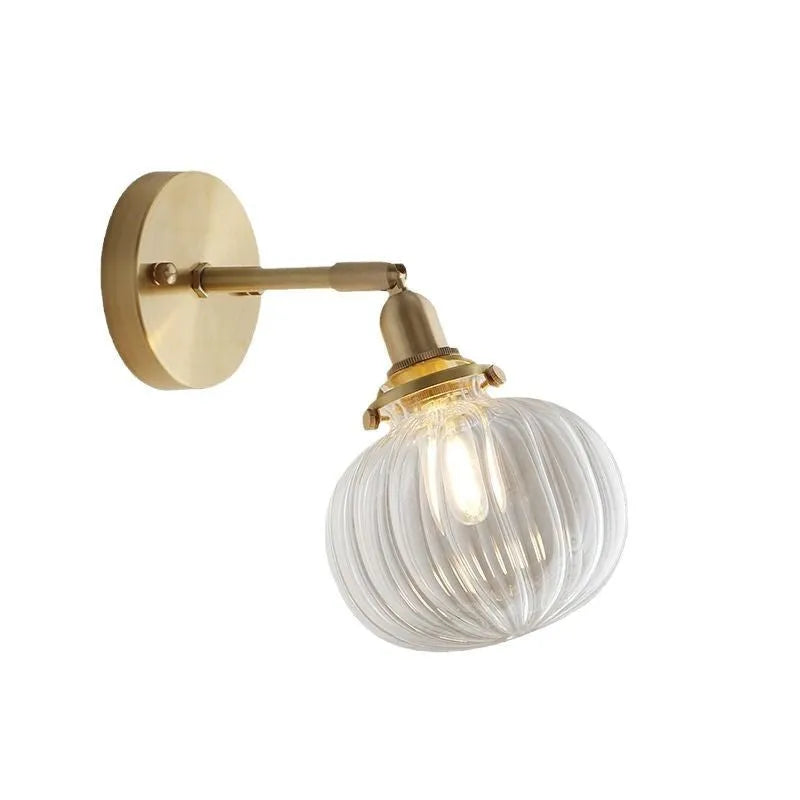 Pumpkin-shaped glass wall lamp in blue and transparent water ripple finishes mounted on a wall.