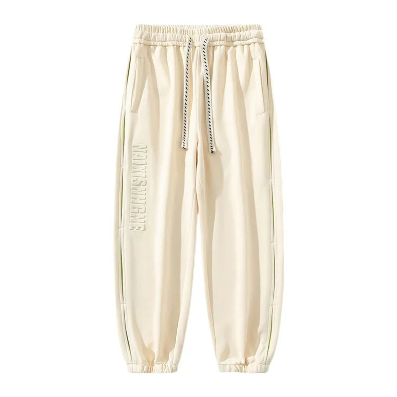 Men's loose fit cotton trousers with stitching detail and a banded ankle cuff.