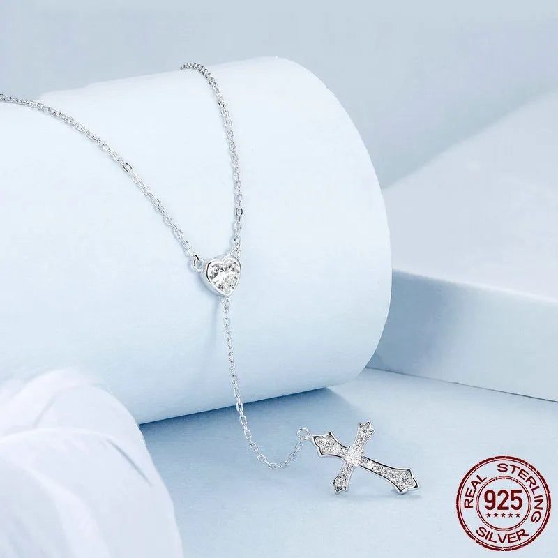 Simple silver love cross pendant necklace with O-ring chain on a V-neck.