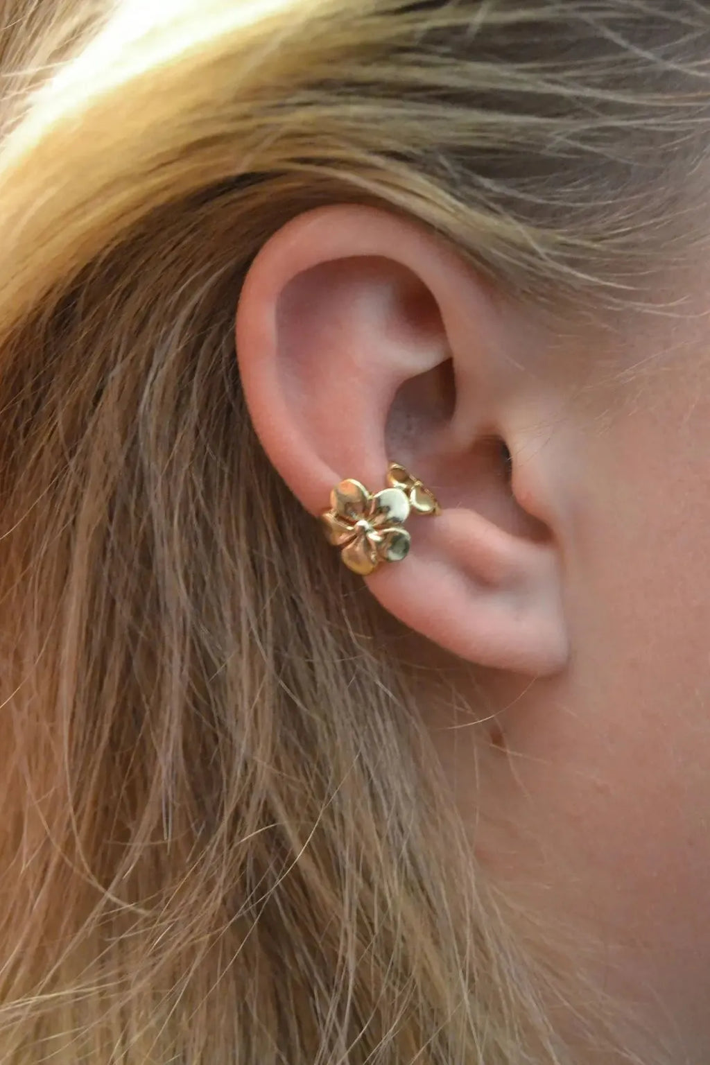 Gold-coloured drop earrings with a detailed starfish and conch shell design on a white background.