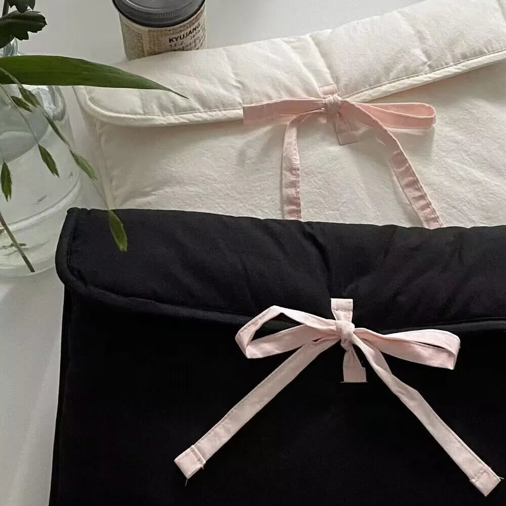 Black and white striped quilted laptop bag with a ballet-style bow.