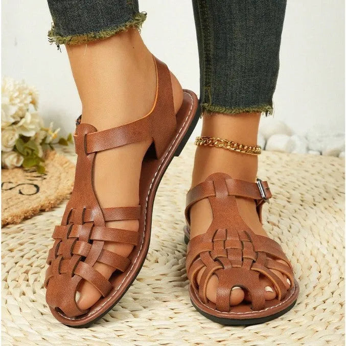 Dark brown women's Roman sandals with woven PU upper and buckle closure on a rubber sole.
