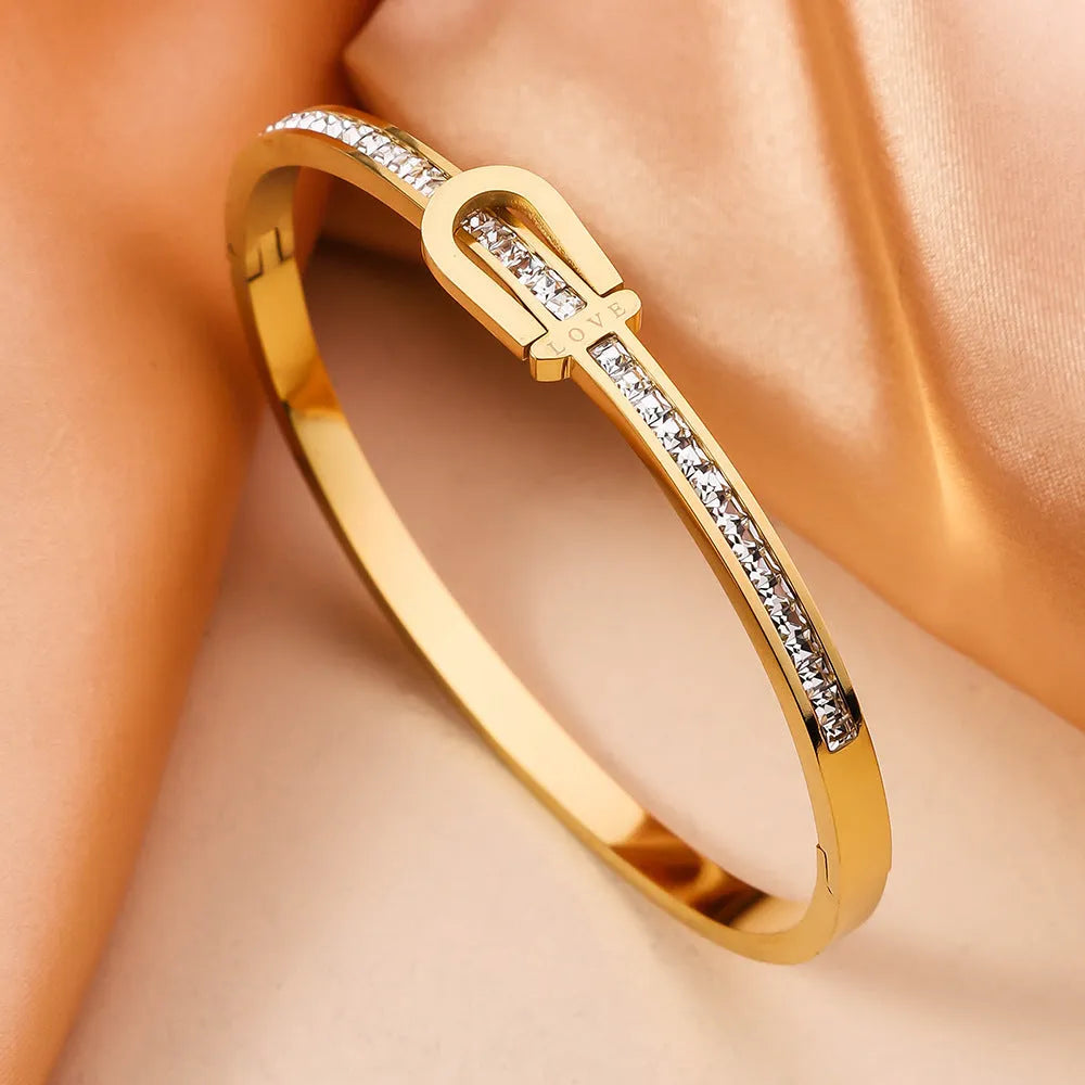 Gold plated titanium steel bangle bracelet with gang drill style, available in gold and steel colours.