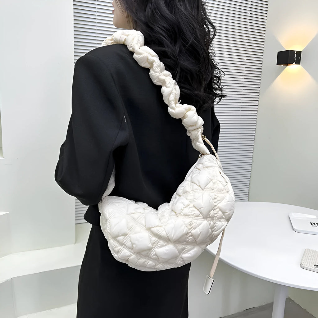 Women's light beige nylon cloud underarm messenger bag with a long adjustable shoulder strap.