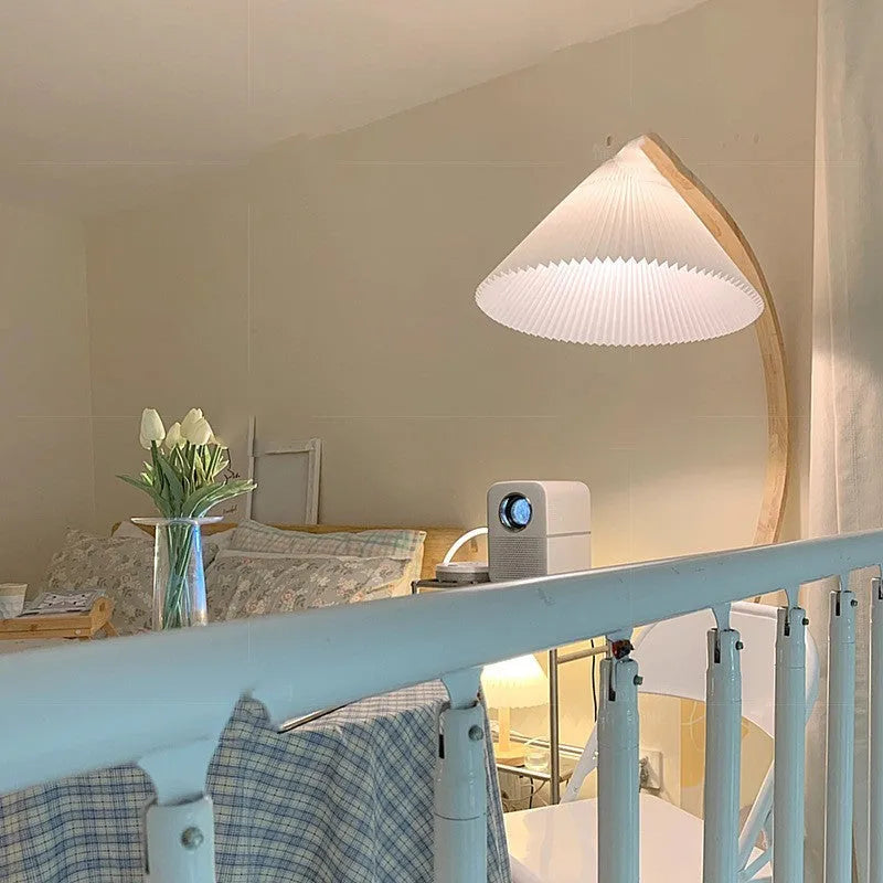 Retro vertical table lamp with a fabric shade in log white, placed on a bedside table.