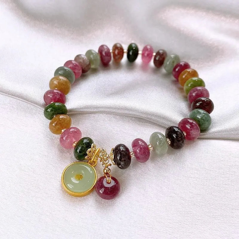 Close-up of a colourful tourmaline rabbit pendant bracelet with natural stone round beads.