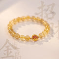 Citrine and gold rutilated quartz bracelet with diamond faceted beads on a wrist.