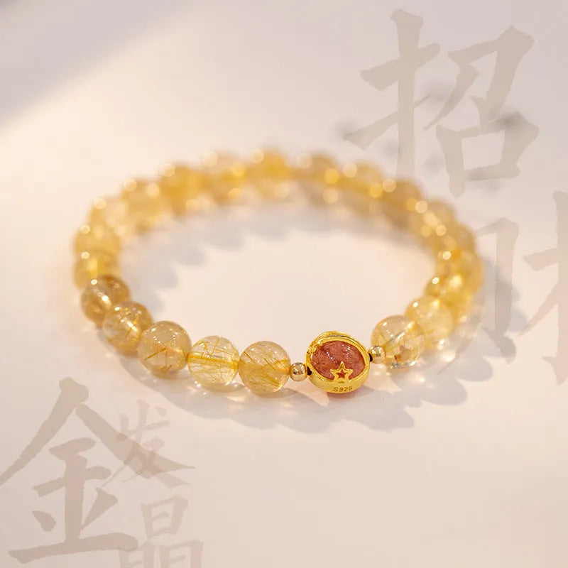 Citrine and gold rutilated quartz bracelet with diamond faceted beads on a wrist.