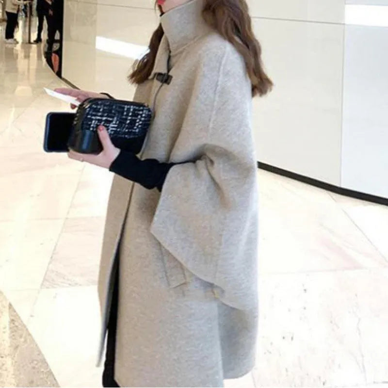Women's long oatmeal-coloured acrylic coat with half-length flight sleeves, shown on a model.
