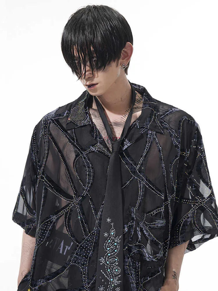 Man wearing a black and grey translucent snake pattern short-sleeved shirt with a lapel collar.
