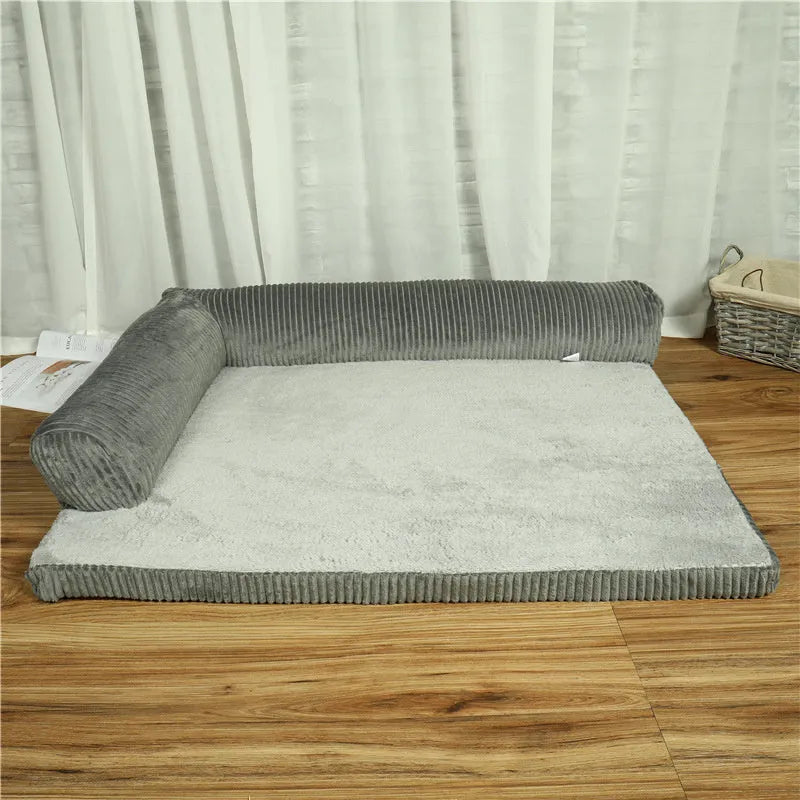 Large grey corduroy dog sofa bed with raised sides on a wooden floor