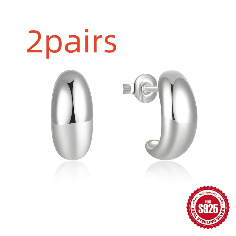 A single C-shaped glossy stud earring made of sterling silver, shown in a gold colour finish.