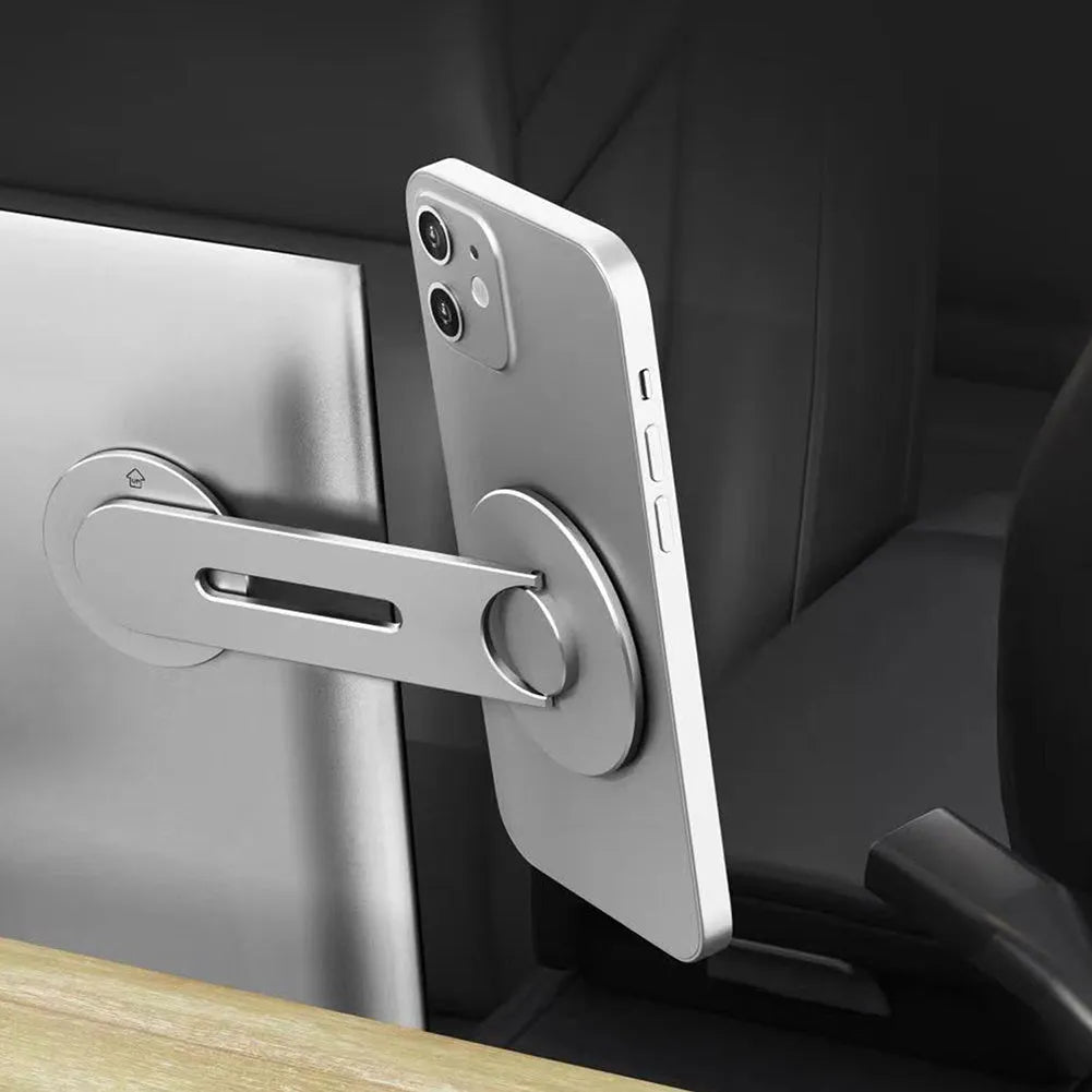 Silver aluminium alloy magnetic car phone holder with 180-degree flip rotation on a car dashboard.