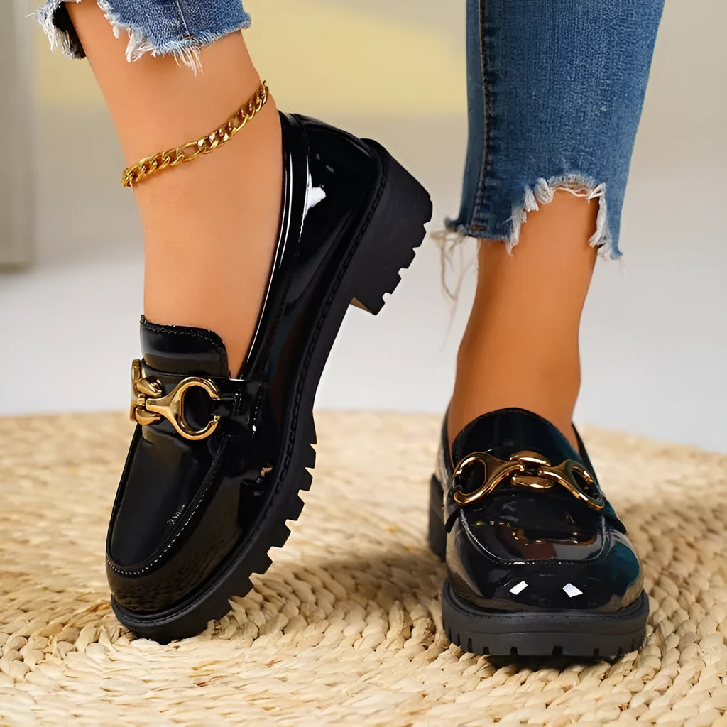Black women's chunky heel round toe pumps with a thick rubber sole and metal detail on a white background.