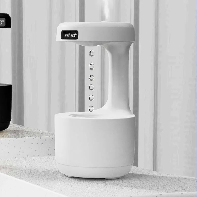 White columnar anti-gravity humidifier on a desk with LED clock display and visible mist.
