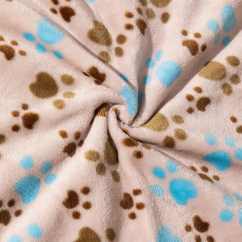 Blue cartoon dog paw print pattern on a thick double-sided flannel pet blanket laid flat.