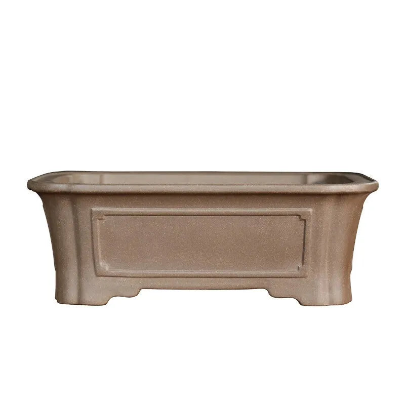 Rectangular antique purple sand bonsai pot with cut corners on a floor.