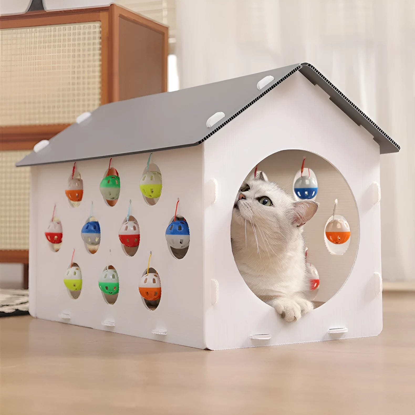 White plastic cat scratch board with integrated enclosed nest, tunnel, and hanging bell ball toy.