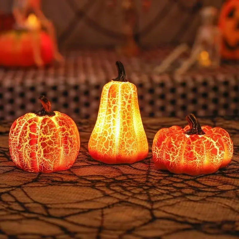 Three LED pumpkin lanterns in different sizes with realistic surface cracks and candle-like glow
