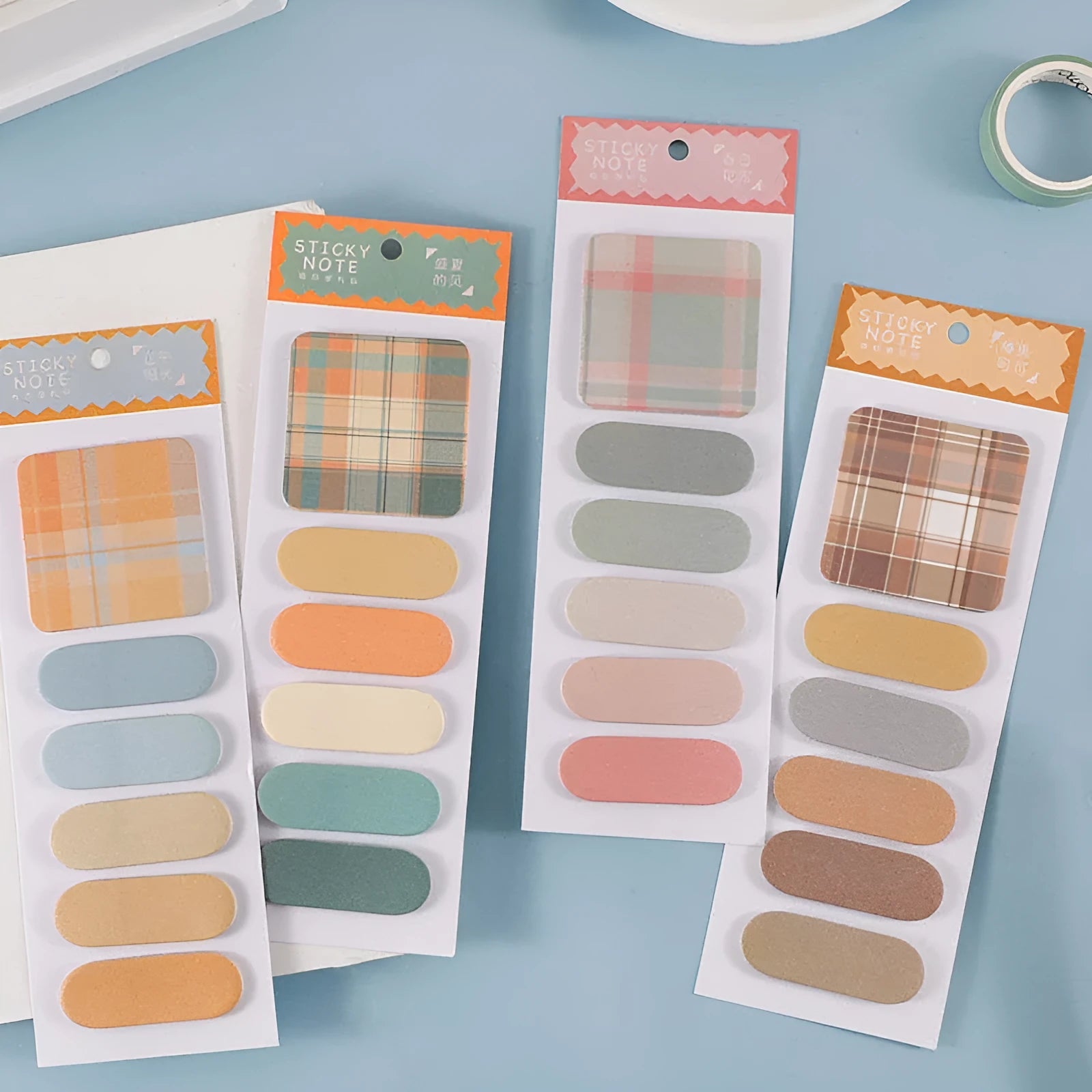 Set of six colourful memo pads with sticky notes, showing plaid and solid colour designs like Spring Garden and Twilight Coast.