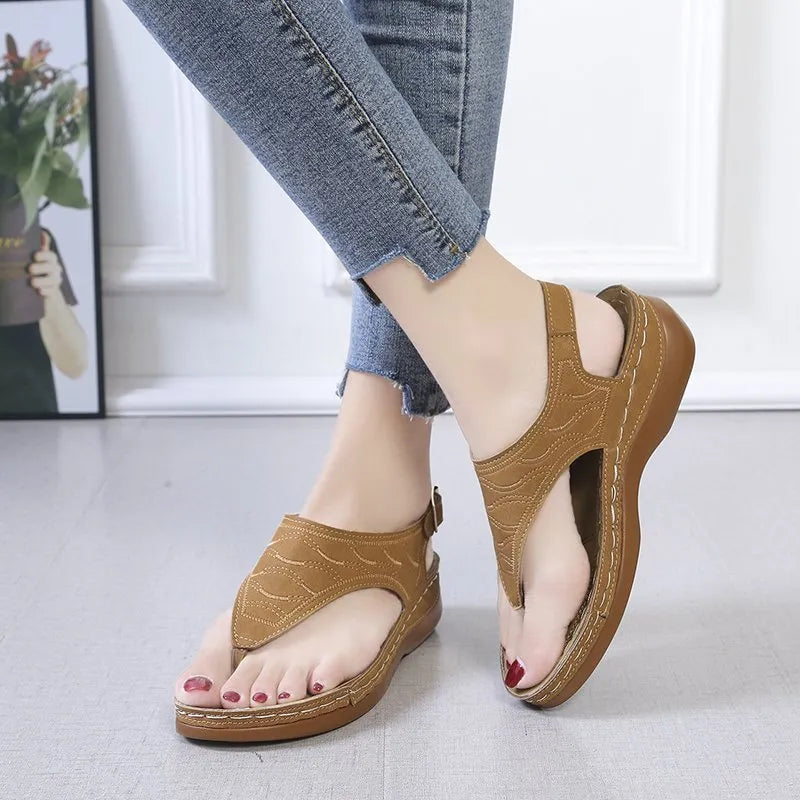 Women's casual wedge heel flip flop sandal in black with adjustable buckle strap.