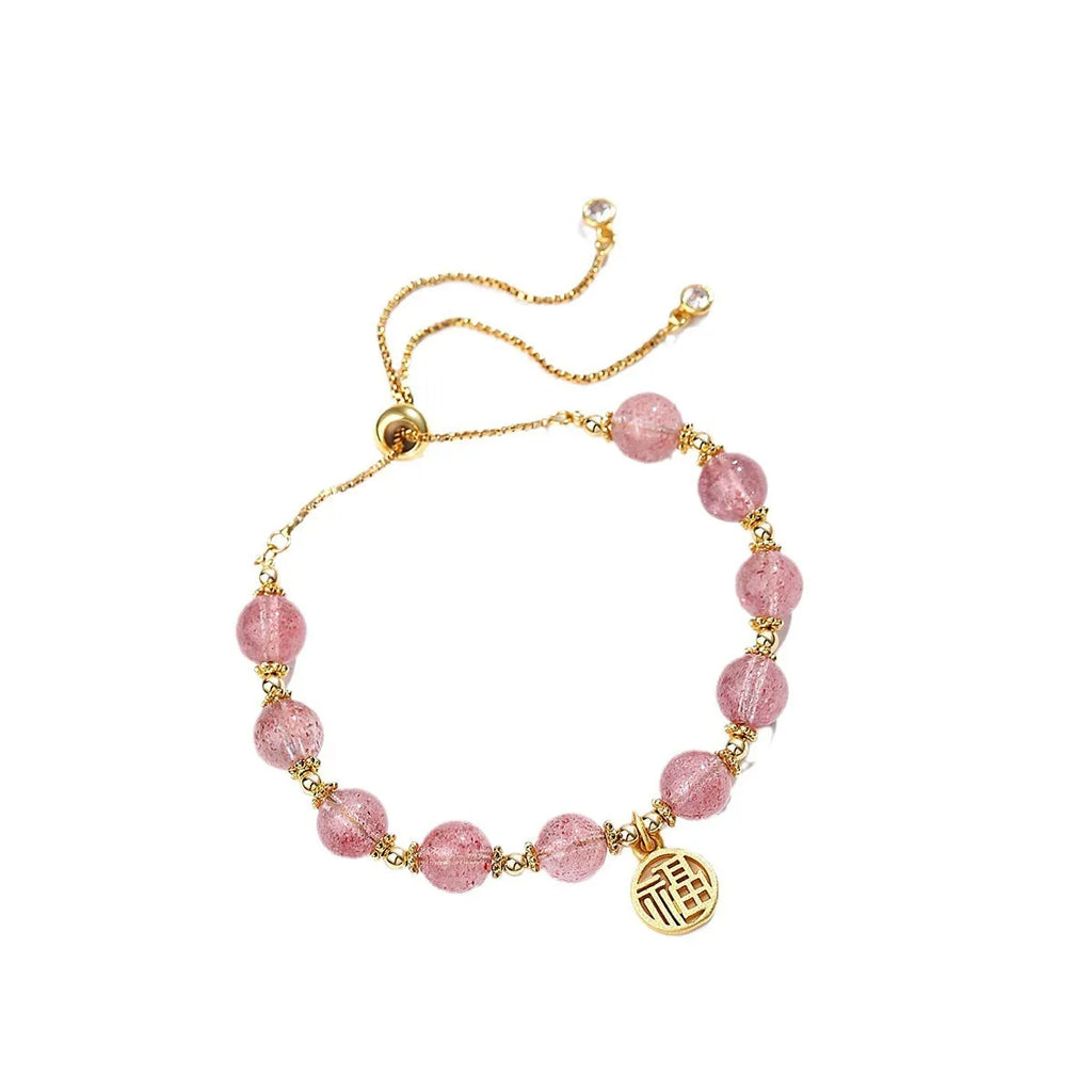 Women's strawberry quartz bracelet with a geometric fu character charm on an electroplated chain.