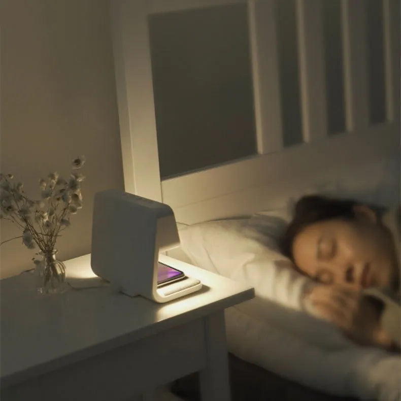 White 3-in-1 bedside lamp with wireless charging pad, LCD alarm clock display, and touch controls.